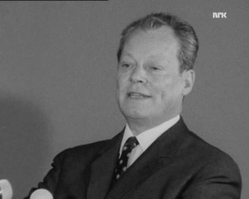 Leicht verpixeltes Schwarz-Weiß Porträt von Willy Brandt aus dem Jahre 1970. Am unteren rechten Rand sind leicht zwei Mikrophone zu erkennen. In der oberen rechten Ecke ist das Logo nrk zu sehen.